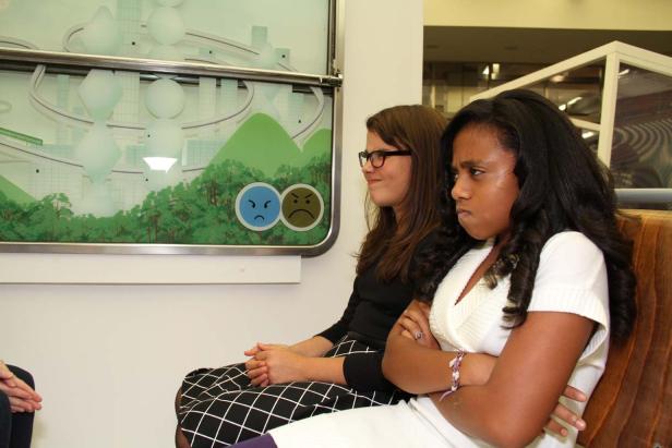 Zwei Frauen sitzen nebeneinander und schauen grimmig.