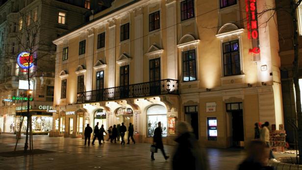Die Kärntner Straße in Wien bei Nacht mit Passanten und dem Casino Wien.