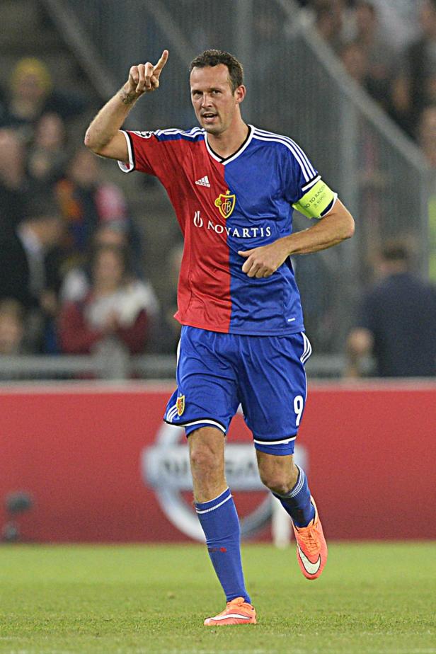 Ein Fußballspieler in rot-blauem Trikot jubelt mit erhobenem Zeigefinger.