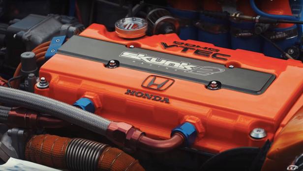 Ein orangefarbener Honda-Motor mit Skunk2-Ventildeckel.