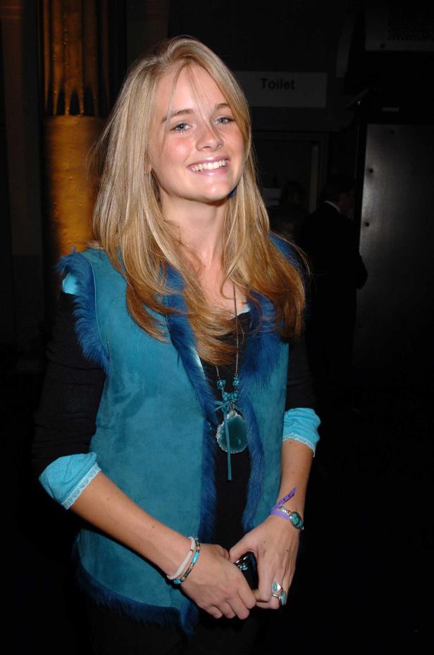 Eine lächelnde junge Frau mit blonden Haaren und einer blauen Weste.