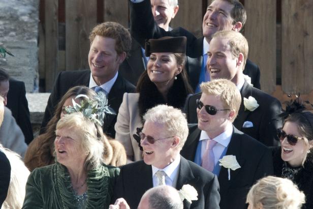 Eine Gruppe von Menschen, darunter Prinz Harry, Kate Middleton und Prinz William, lächeln.