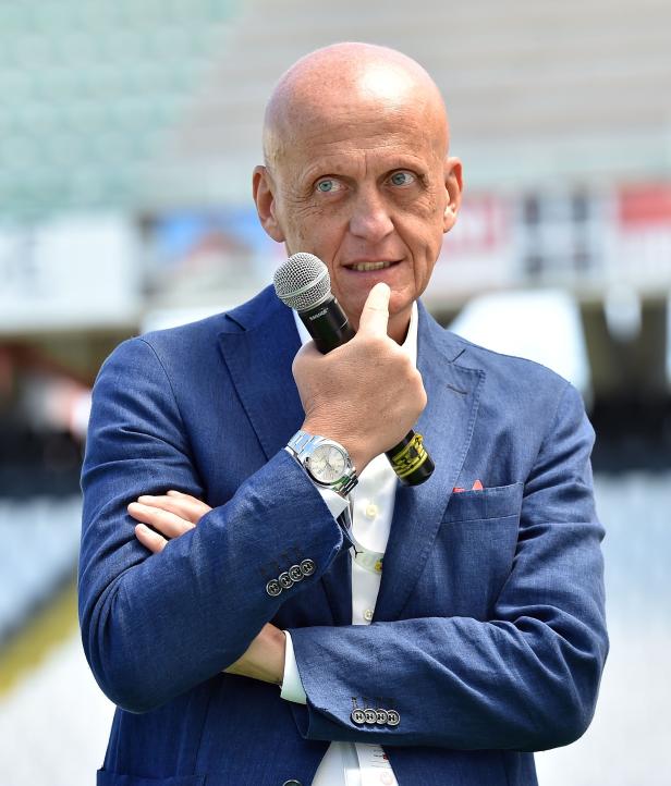 Pierluigi Collina hält ein Mikrofon in der Hand.