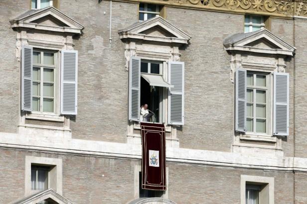 Der Papst hält eine Rede von einem Fenster im Vatikan.