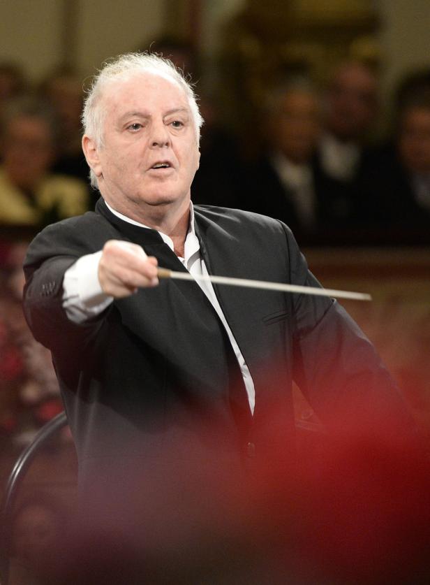 Ein Dirigent mit weißem Haar dirigiert ein Orchester.