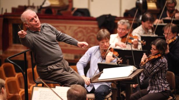 Ein Dirigent leitet ein Orchester mit mehreren Geigenspielern.