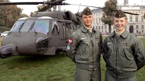 Zwei Soldatinnen stehen vor einem Militärhubschrauber.