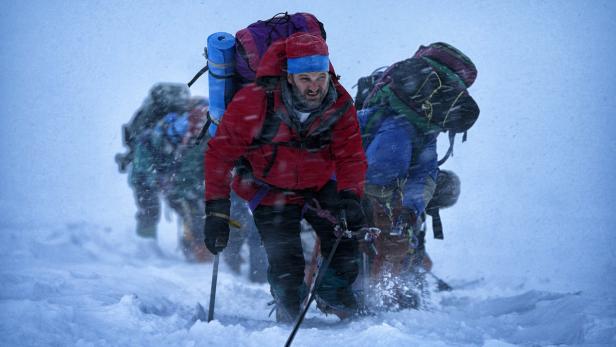Eine Gruppe Bergsteiger kämpft sich durch einen Schneesturm.