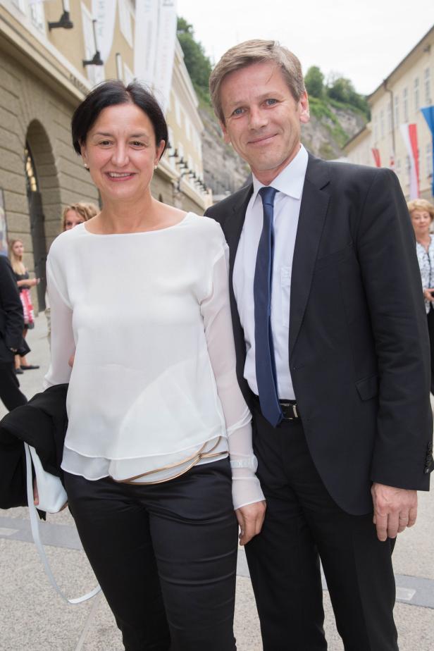 Ein Mann im Anzug und eine Frau in weißer Bluse posieren für ein Foto.