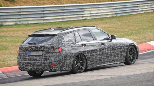 Ein BMW 3er Touring Prototyp mit Tarnmuster auf einer Rennstrecke.