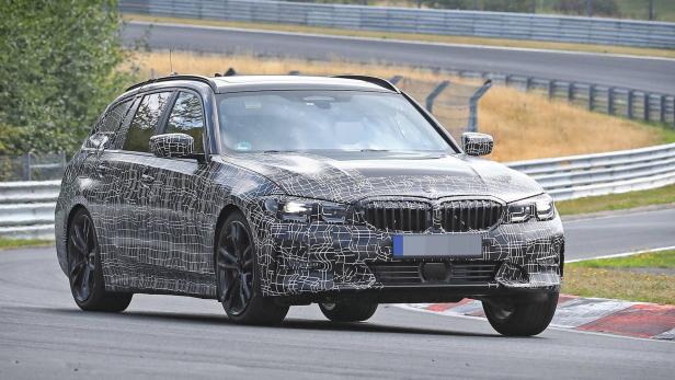 Ein BMW 3er Touring mit Tarnmuster auf einer Rennstrecke.