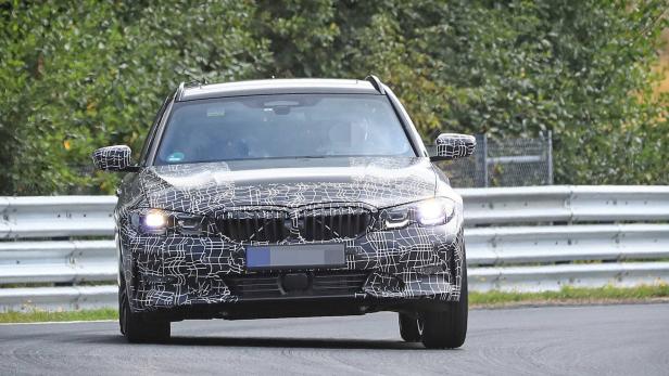 Ein getarnter BMW 3er Touring auf einer Teststrecke.