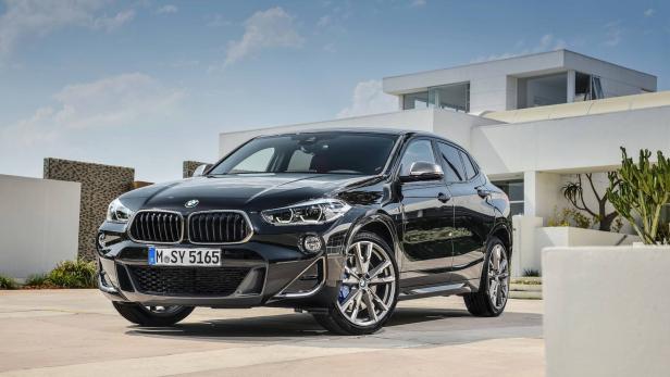 Ein schwarzer BMW X2 vor einem modernen Haus.