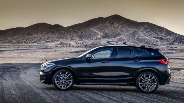 Ein schwarzer BMW X2 vor einer Berglandschaft.