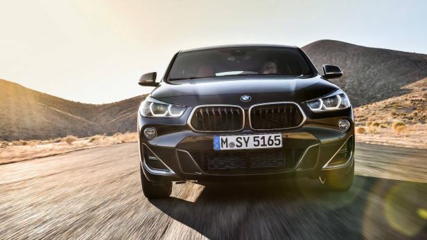Ein schwarzer BMW X2 fährt auf einer Landstraße in Richtung Kamera.