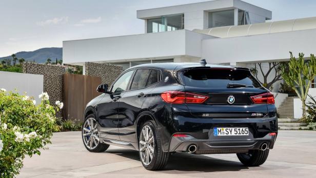 Ein schwarzer BMW X2 M35i steht vor einem modernen Haus.