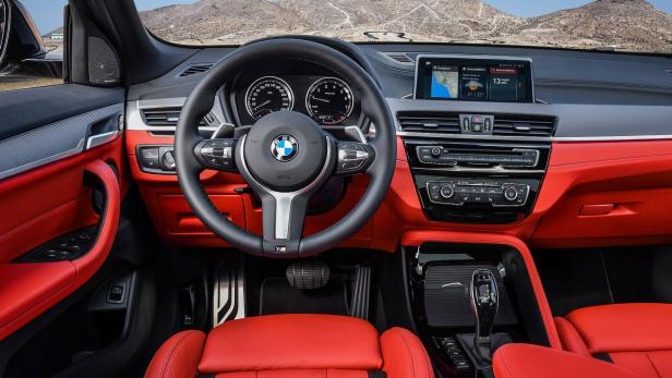 Innenraum eines BMW X2 mit roter Lederausstattung und Blick auf das Armaturenbrett.