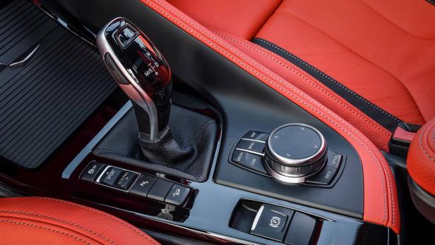 Detailaufnahme des Innenraums eines Autos mit roter Lederausstattung.