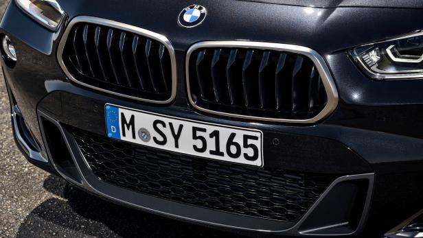Detailansicht der Frontpartie eines schwarzen BMW mit dem Kennzeichen M-SY 5165.