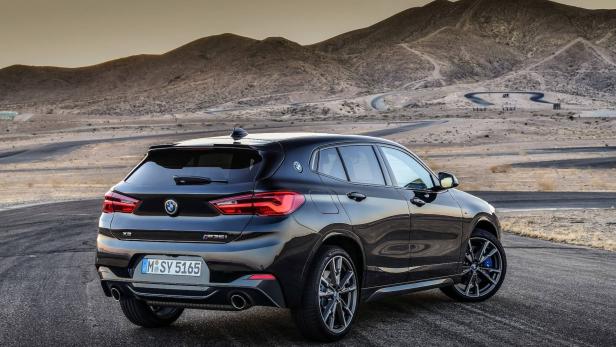 Ein schwarzer BMW X2 M35i steht vor einer Berglandschaft.