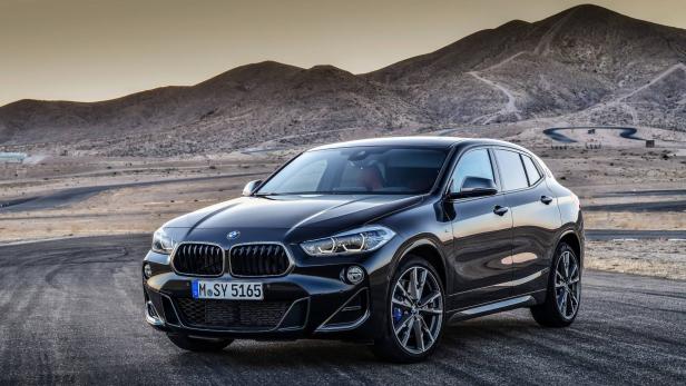 Ein schwarzer BMW X2 vor einer Bergkulisse.