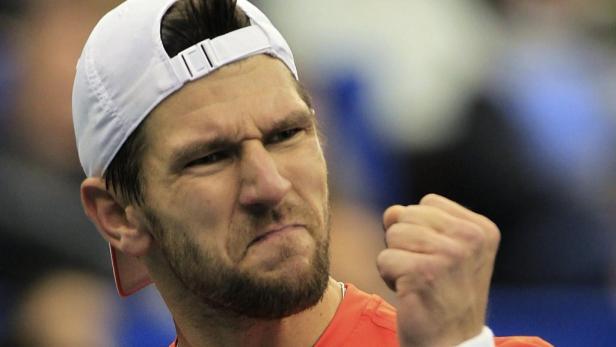 Ein Mann mit weißer Kappe ballt die Faust und blickt grimmig.