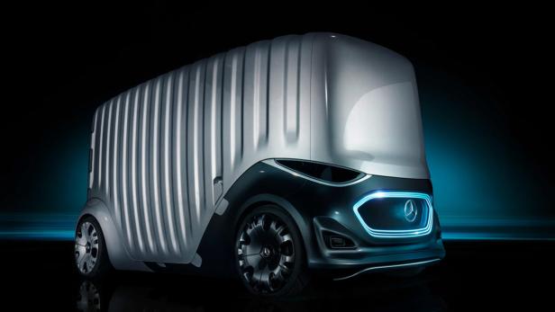 Ein futuristischer, silberner Mercedes-Benz Van mit blauen Akzenten vor dunklem Hintergrund.