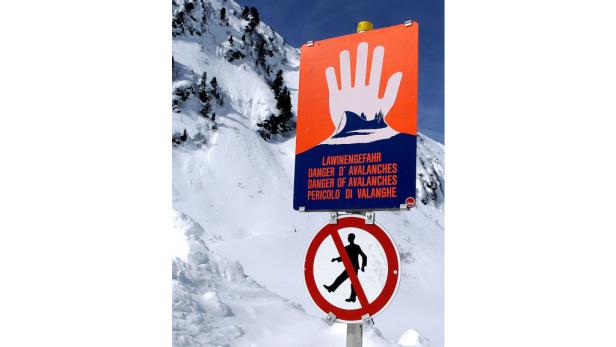Ein Schild warnt vor Lawinengefahr in den Bergen.