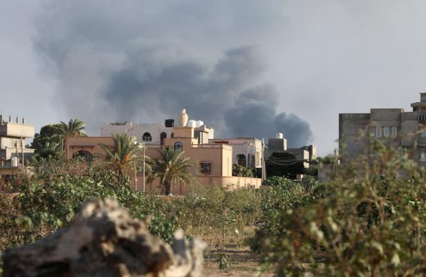 FILE PHOTO: Smoke rises during heavy clashes between rival factions in Tripoli