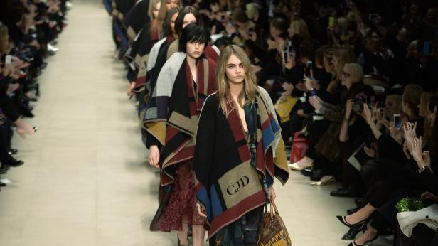 Cara Delevingne und andere Models auf dem Laufsteg während einer Modenschau.