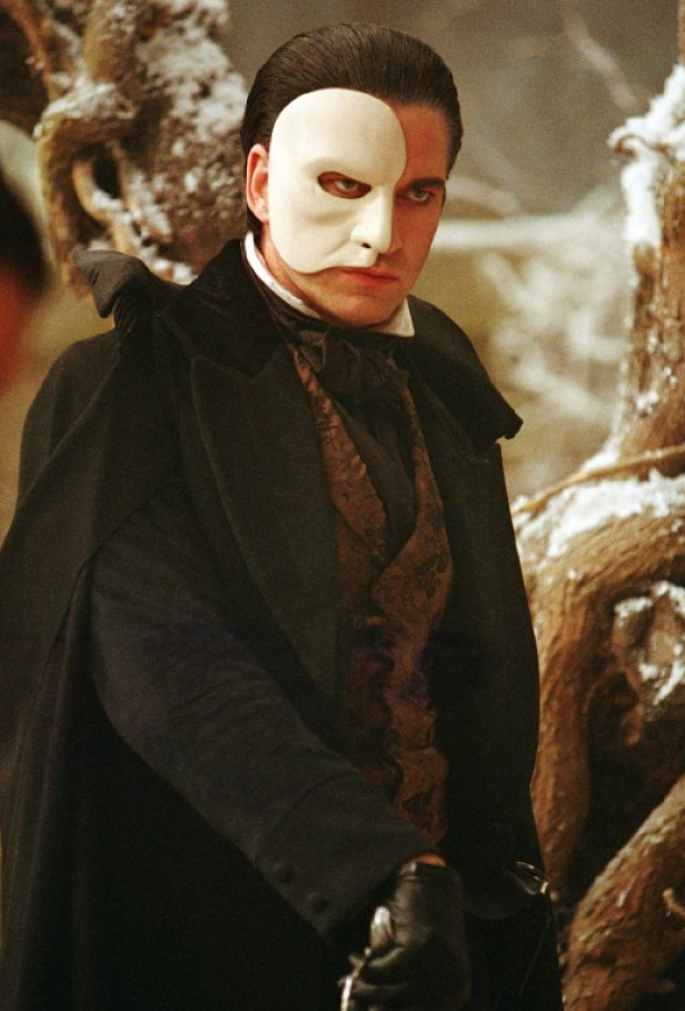Ein Mann mit einer weißen Maske, gekleidet wie das Phantom der Oper.