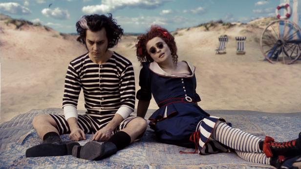 Johnny Depp und Helena Bonham Carter in Kostümen am Strand, möglicherweise eine Szene aus „Sweeney Todd“.