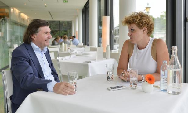 Ein Mann und eine Frau sitzen an einem Tisch und unterhalten sich.