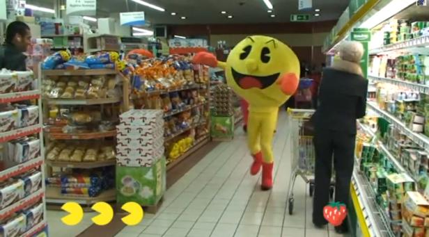 Ein Pac-Man-Kostüm läuft durch einen Supermarkt.