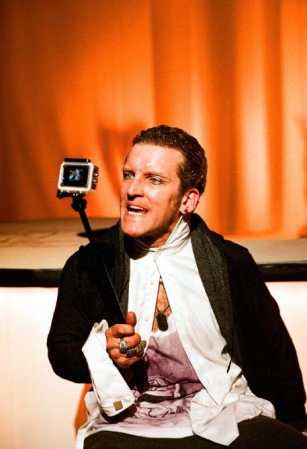 Ein Mann mit theatralischem Make-up filmt sich mit einer GoPro auf einem Selfie-Stick.