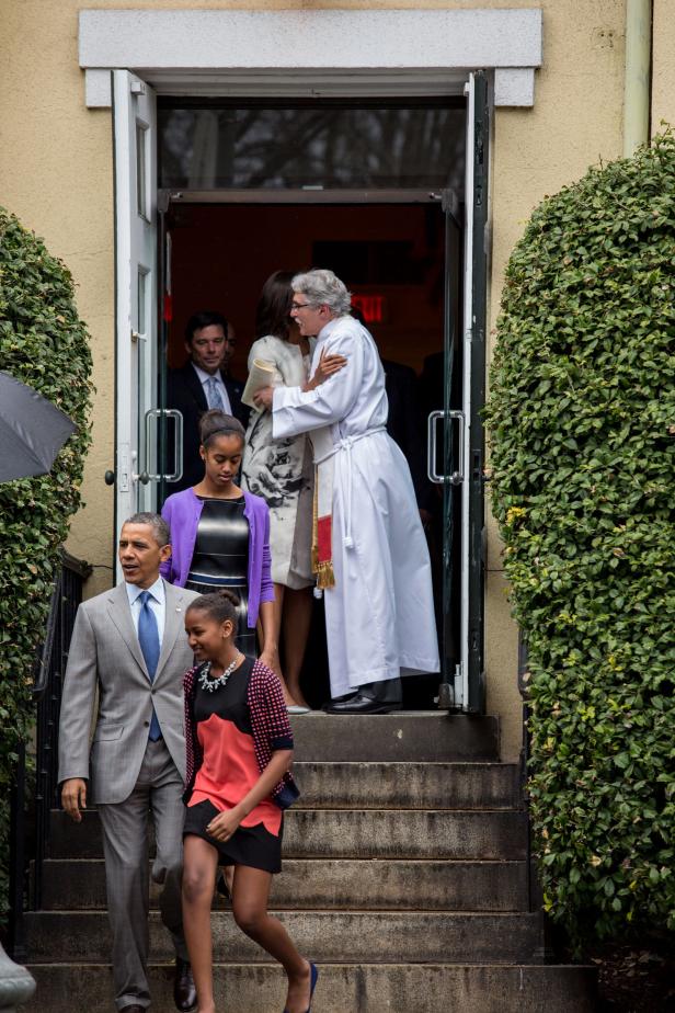 Barack Obama mit Familie verlässt eine Kirche, Michelle Obama umarmt einen Priester.