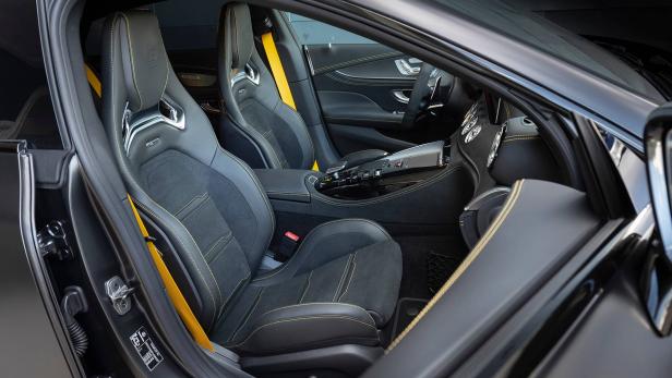Das Interieur eines Autos mit schwarzen Ledersitzen und gelben Akzenten.