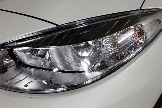 Nahaufnahme eines Scheinwerfers eines weißen Autos.