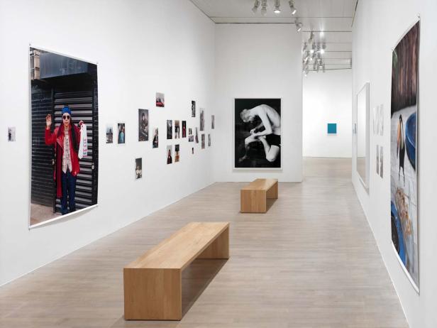 In einer Kunstgalerie hängen verschiedene Fotografien an den weißen Wänden.