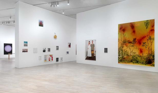 In einer Kunstgalerie hängen verschiedene Kunstwerke an den weißen Wänden.