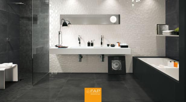 Ein modernes Badezimmer mit grauen Fliesen, einer Dusche und einer freistehenden Badewanne.