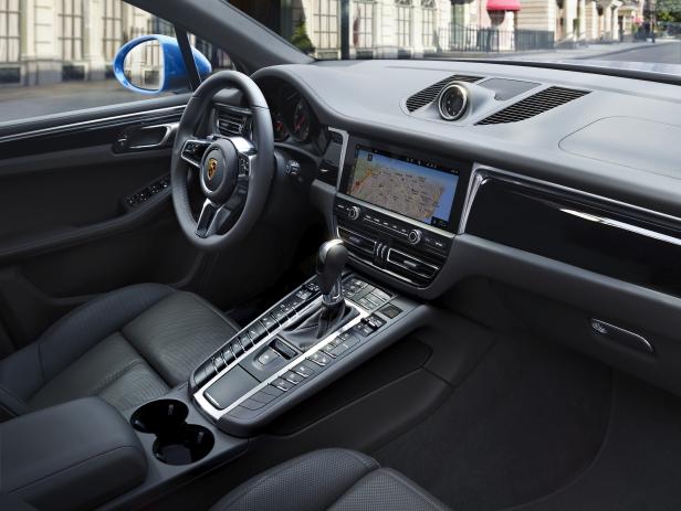 Innenansicht eines Porsche Macan mit Navigationssystem, das eine Karte von Lissabon anzeigt.