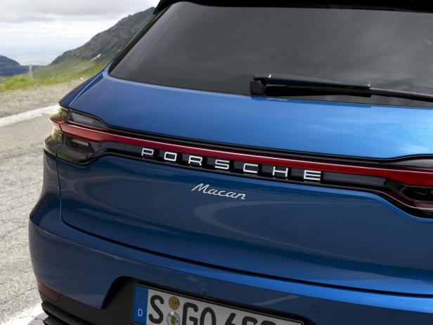 Die Rückansicht eines blauen Porsche Macan mit dem Schriftzug „Porsche“.