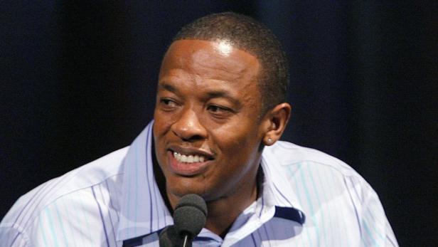 Dr. Dre spricht bei einer Veranstaltung in ein Mikrofon.