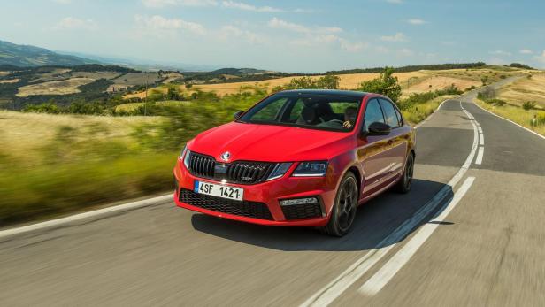 Ein roter Škoda Octavia fährt auf einer Landstraße.