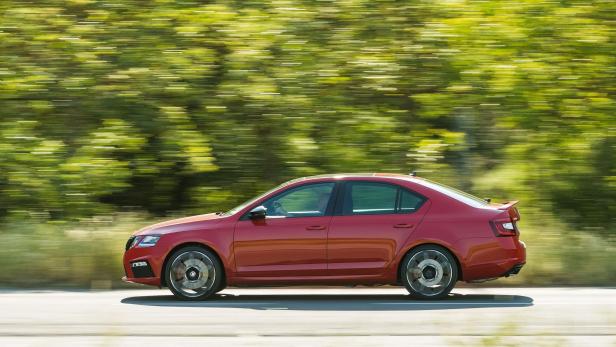Ein roter Škoda Octavia fährt auf einer Landstraße.