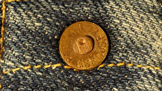 Nahaufnahme eines Jeansknopfes mit der Aufschrift „PAT. MAY 1873“.