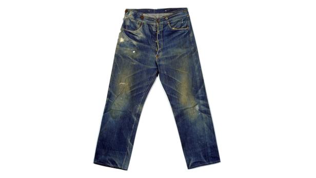 Eine gebrauchte, blaue Jeans liegt auf einem weißen Hintergrund.