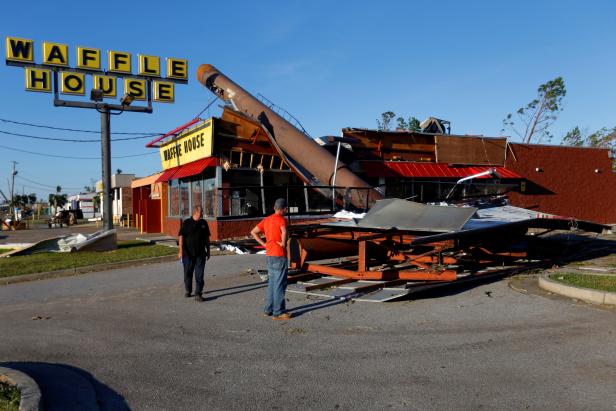 People inspect a Waffle House damaged by Hurricane Michael in Callaway,