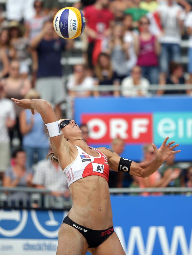 Eine Beachvolleyballspielerin schlägt den Ball bei einem Spiel auf Sand.